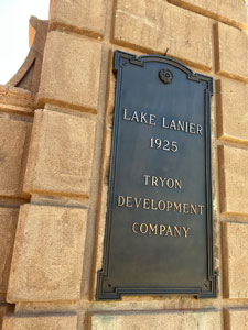 Metal sign attached to brick post at entrance to Lake Lanier.
